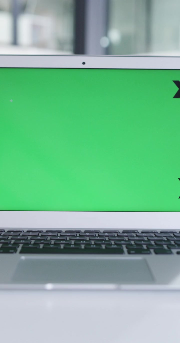 Laptop with Green Screen Display on Office Desk