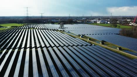 cinematic aerial shot of solar panels in grass field in the netherlands