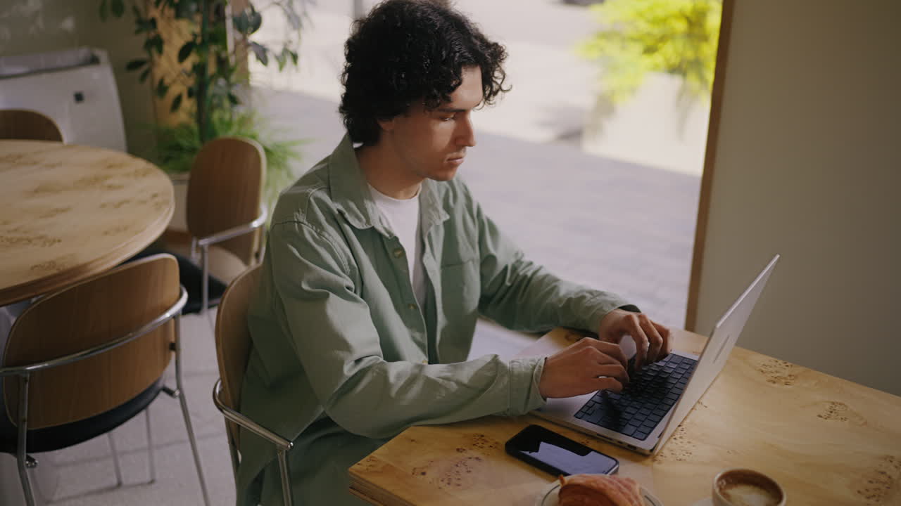 A man working on his laptop in a cafe