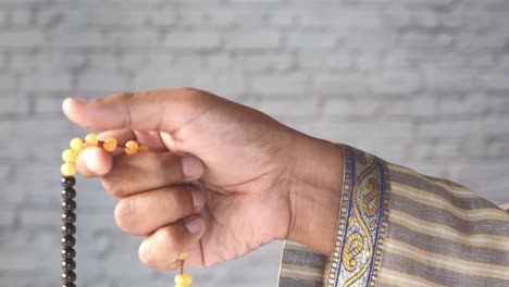 person holding prayer beads