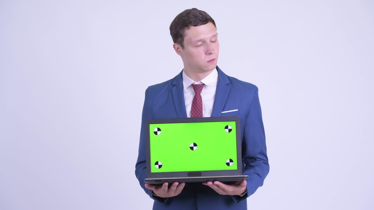 feliz joven hombre de negocios guapo en traje con computadora portátil