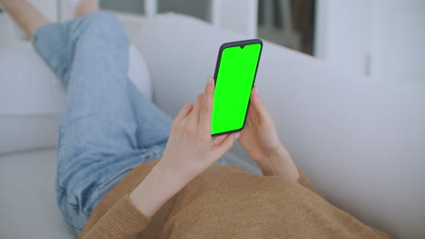 La-Joven-Sostiene-Un-Teléfono-Inteligente-Con-Pantalla-Verde-Por-La-Noche.-Imágenes-Estáticas-Del-Teléfono-Inteligente-En-La-Mano-Con-Pequeños-Movimientos-De-La-Mano.-Indicadores-En-Pantalla-Para-Seguir-El-Movimiento.