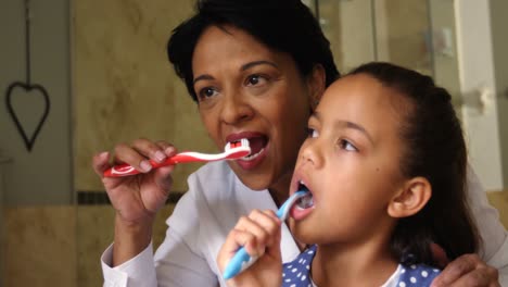 Grandmother-and-granddaughter-brushing-together-in-bathroom-4k