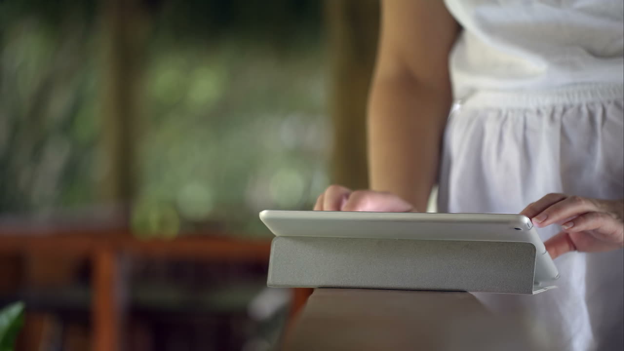 Donna che usa un tablet appoggiata al corrimano
