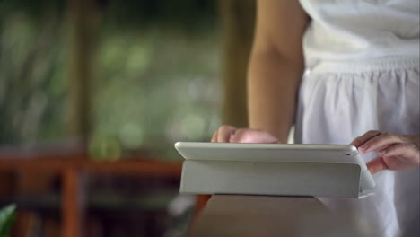 Woman-using-tablet-computer-on-handrail