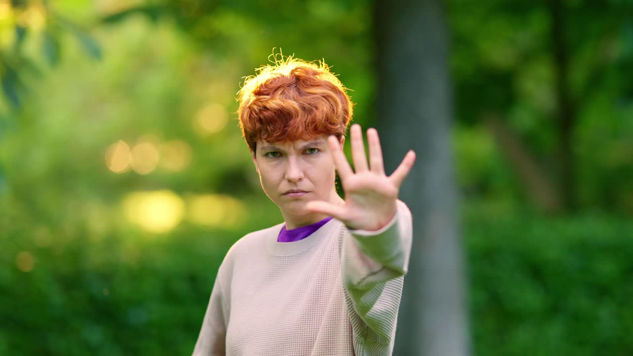 Woman making a stop gesture outdoors