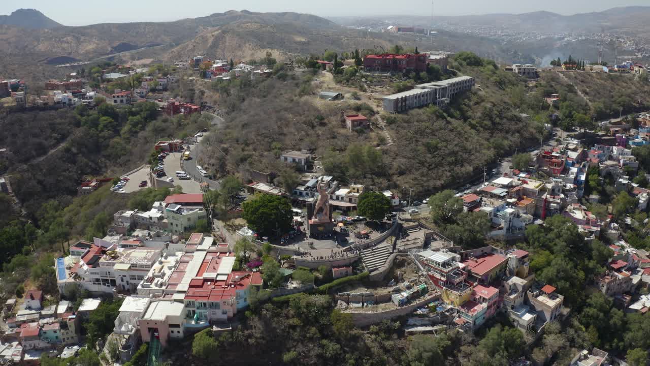 un dron aéreo se disparó hacia adelante sobre una estatua masculina dorada en las colinas de tijuana, méxico, a primera hora de la mañana
