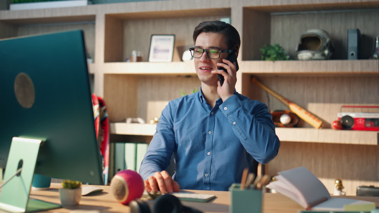 Trabajador autónomo feliz llamando por teléfono móvil en la oficina. Chico sonriente contestando una llamada de smartphone.