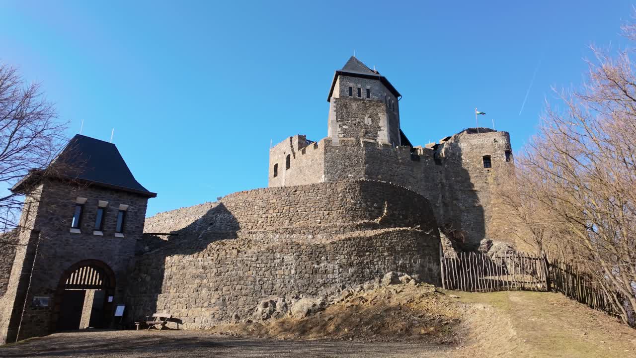 Orbit shot of a Ancient stone castle in Hollókő, Hungary, with fortified walls and medieval towers. A UNESCO World Heritage site, showcasing defensive architecture and cultural history.