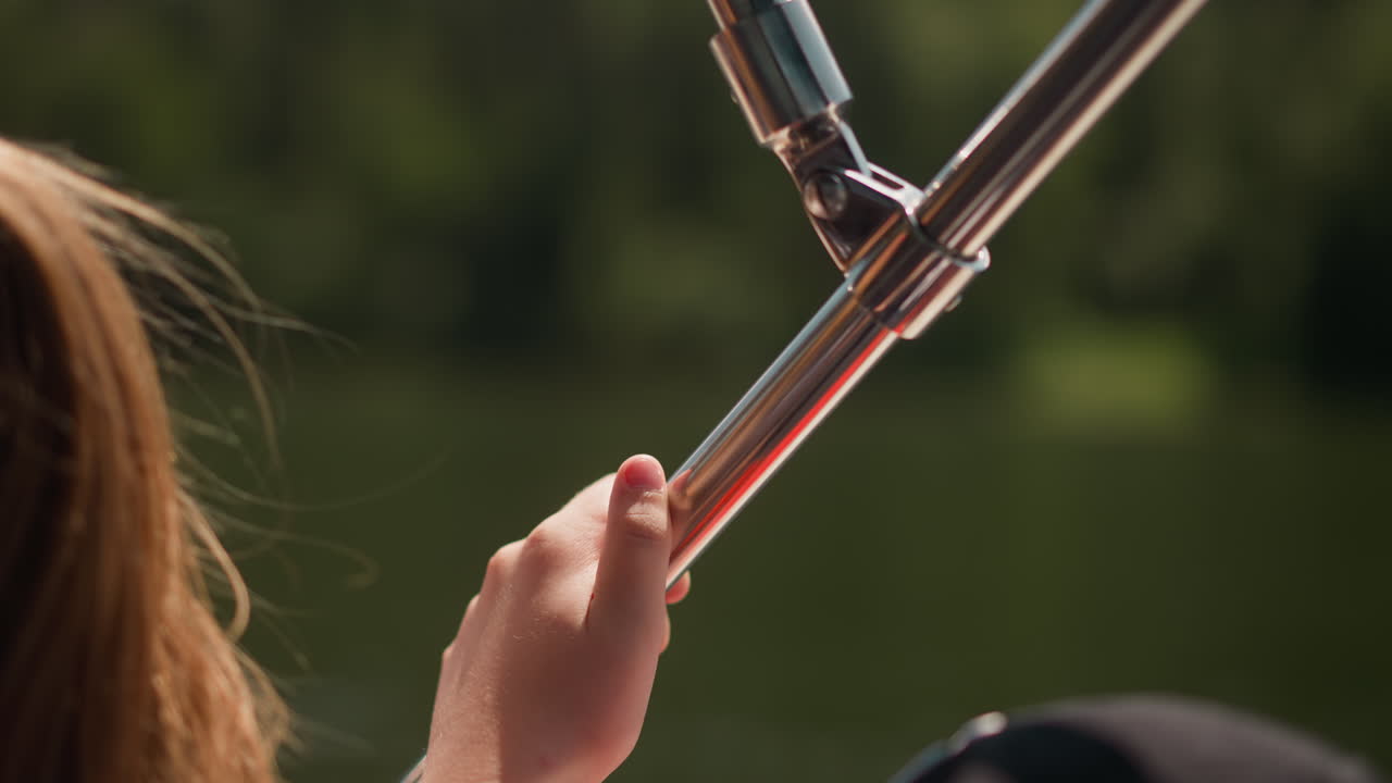 niña pequeña sostenida por una barandilla de metal disfrutando de una moderna excursión en yate en primer plano de verano. niño navega en una lancha turística a la orilla del mar. excursión de transporte acuático