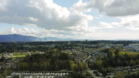 Suburban-small-city-with-mountains-in-the-distance-under-bright-cloudy-sky