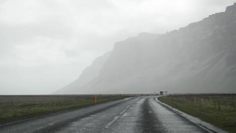 coche conduciendo por la carretera mojada de islandia bajo la lluvia en cámara lenta