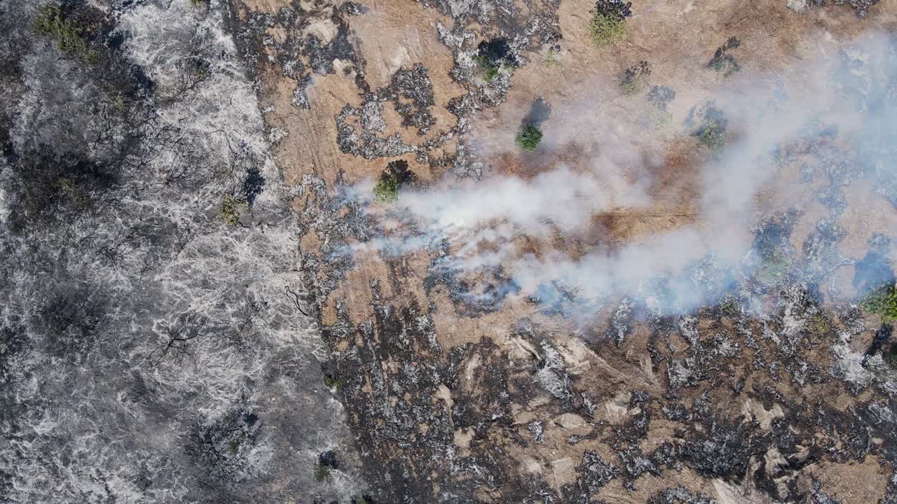 vista giratoria artística del humo que se levanta desde el suelo creando patrones en la tierra quemada. vista de avión no tripulado de alto