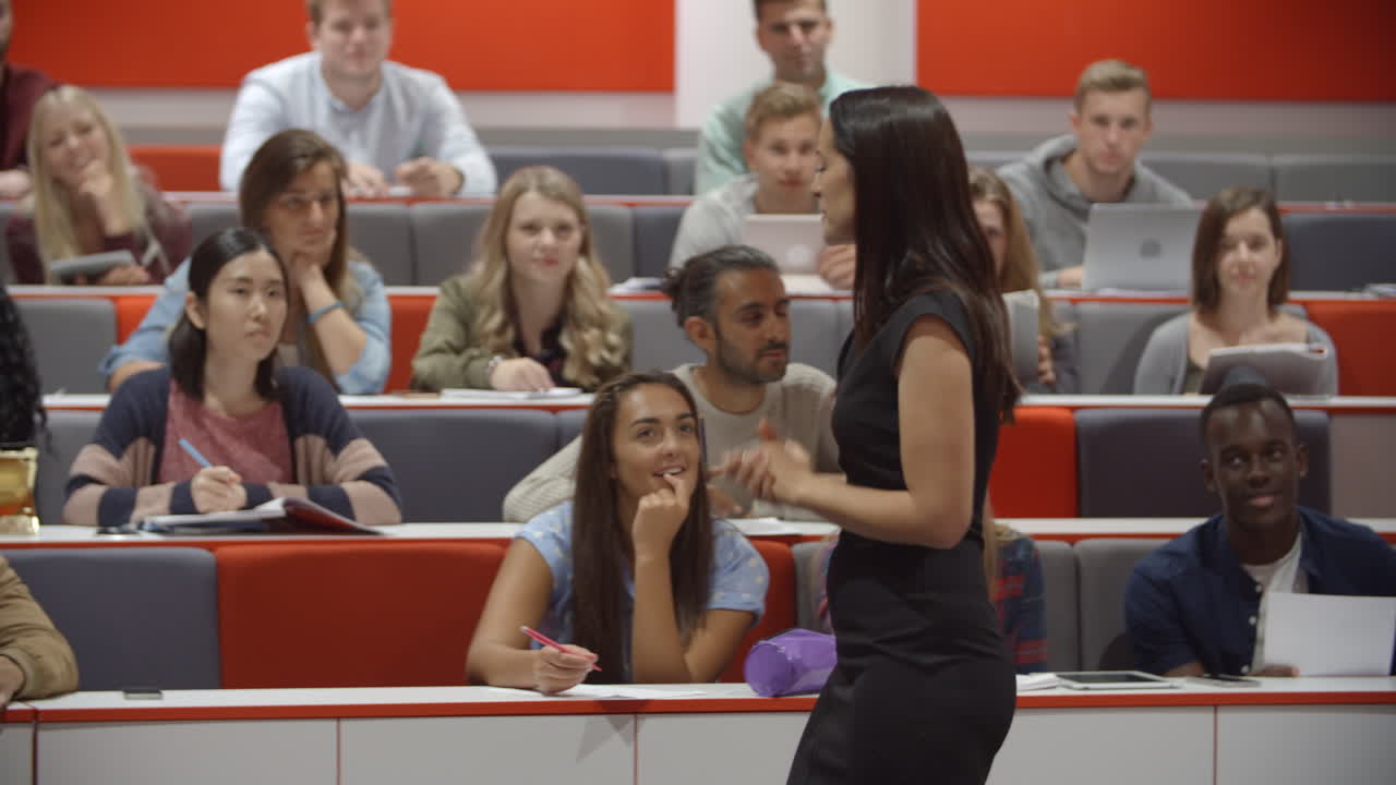 Female teacher and students in university lecture theatre