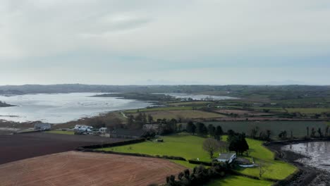 County-Down-Ireland-drone-shot-over-countryside-hazy-Mourne-mountains-in-the-distance