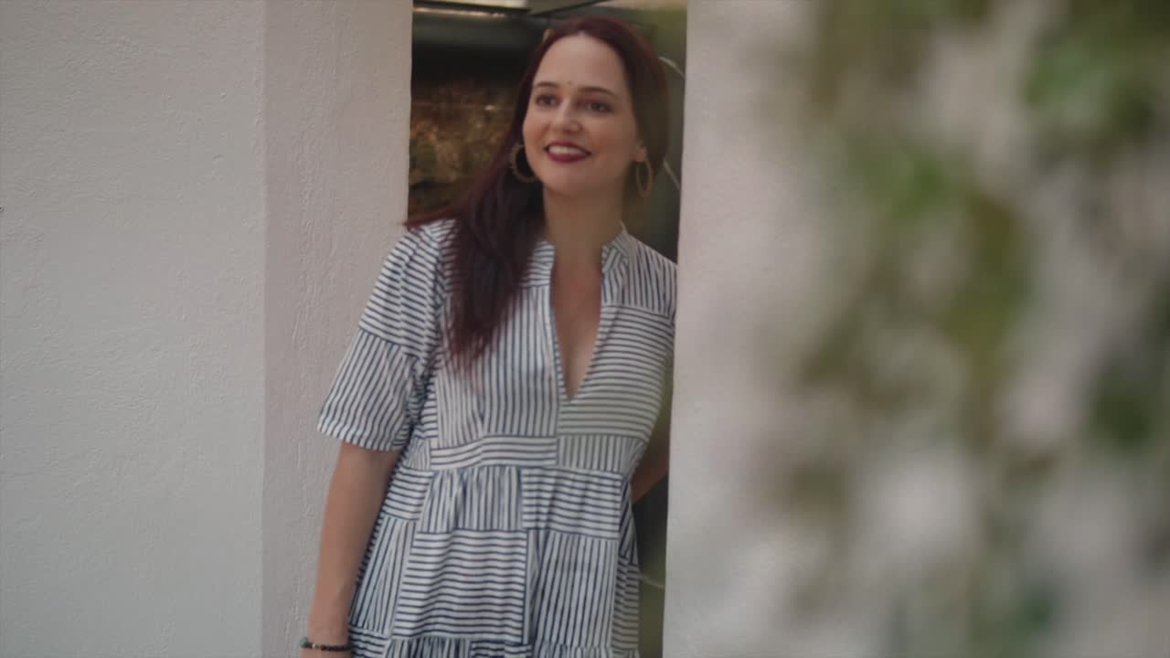 Beautiful Woman in a Striped Dress Smiling Outdoors