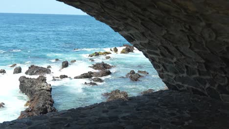 view of ocean coastline from inside cave, slow motion