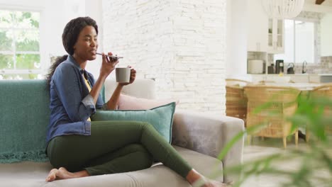 Video-Einer-Glücklichen-Afroamerikanischen-Frau-Auf-Dem-Sofa-Mit-Smartphone