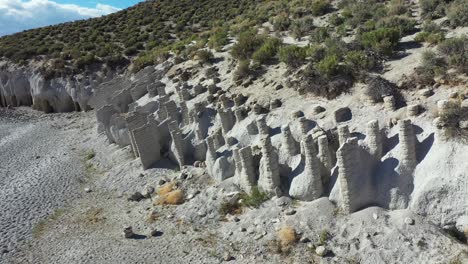 crowley lake scenic coastline drone aerial view of scenic mysterious columns and pillars by water reservoir, california usa