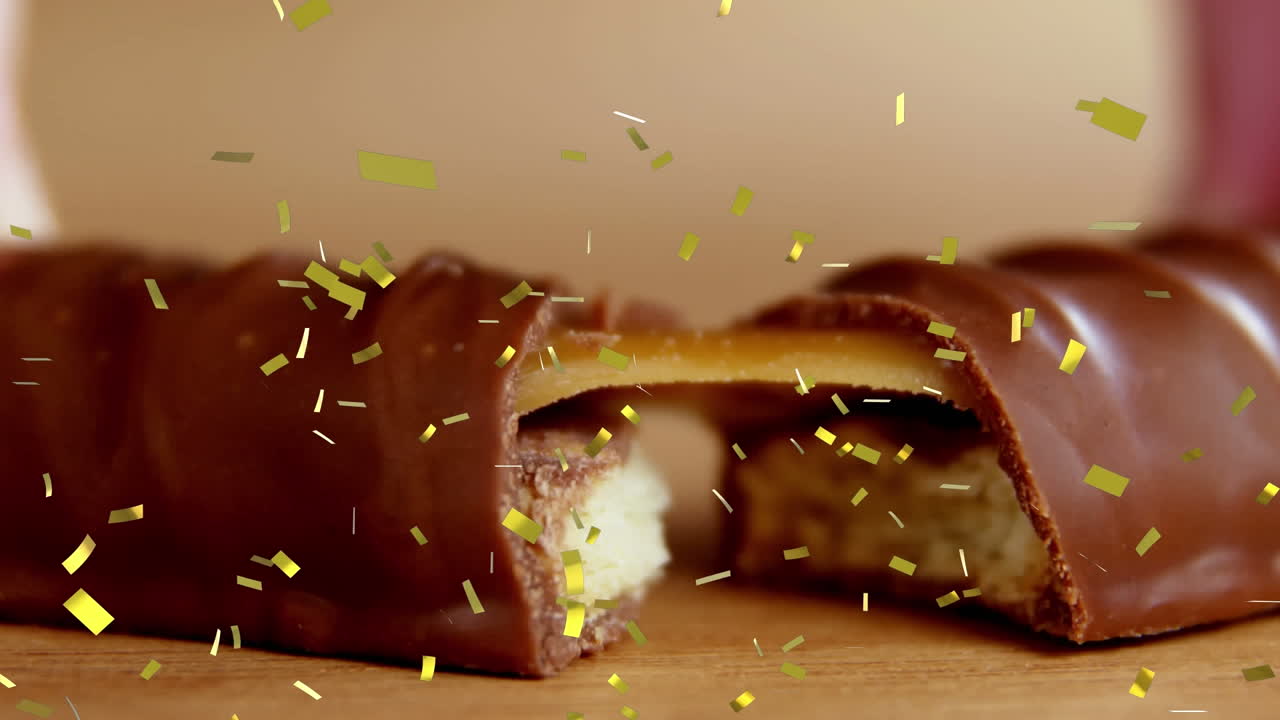 animación de confeti dorado cayendo sobre galletas rotas y barra de chocolate de caramelo
