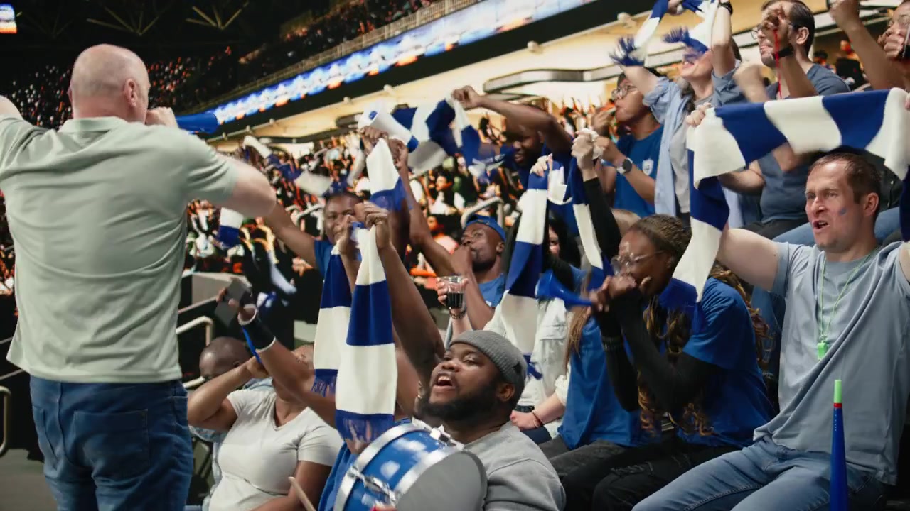Football chant leader blowing vuvuzela while blue supporters respond