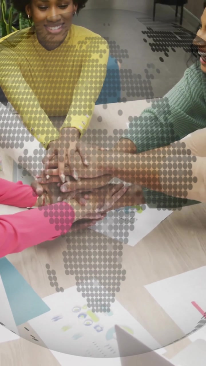 Diverse team collaborating at table with digital globe animation overlay
