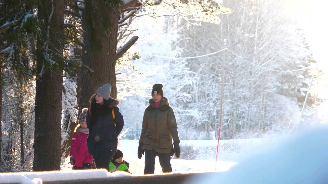 Kvinner og barn går i vinterlandskap, sakte film