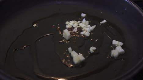 chef frying and mixing garlic and chili peppers