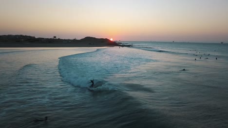 surfing on pacific ocean waves at sunset