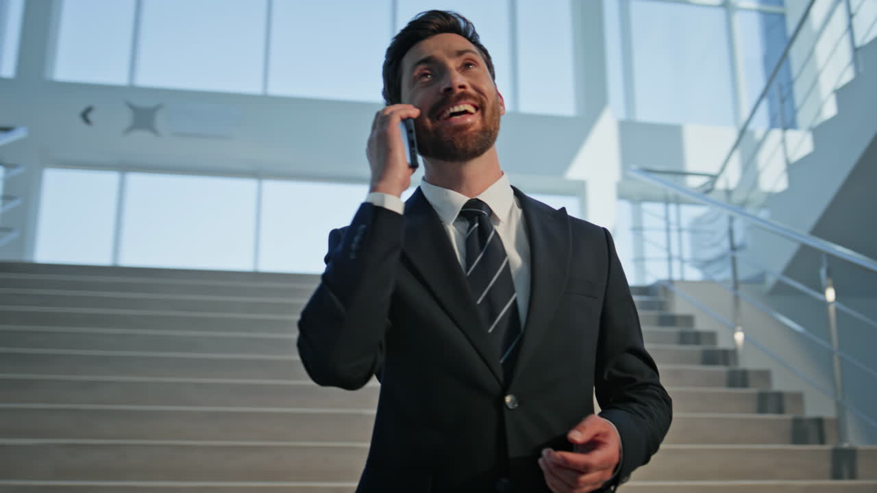 Businessman enjoying friendly call on office stairs closeup. Confident manager