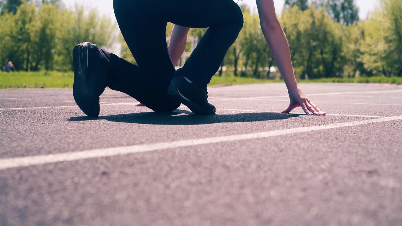 CU, Back shot: Young cute girl, sporty physique, at the stadium. She goes to the start line