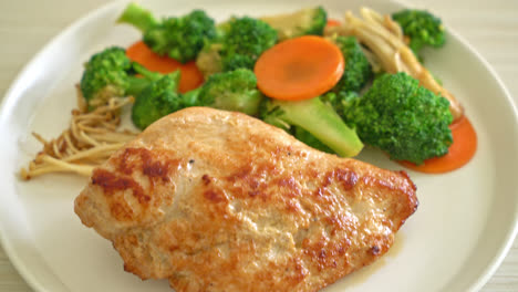 filete de pollo a la parrilla con verduras en un plato blanco