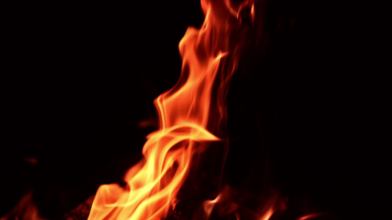 Fire flames rising diagonally in the air. Bonfire burning isolated at black backdrop.