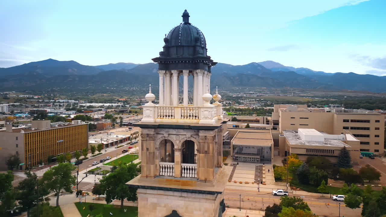 Rising to the top of Colorado Springs Pioneers Museum. Revealing view on the cityscape surrounded by mountain range