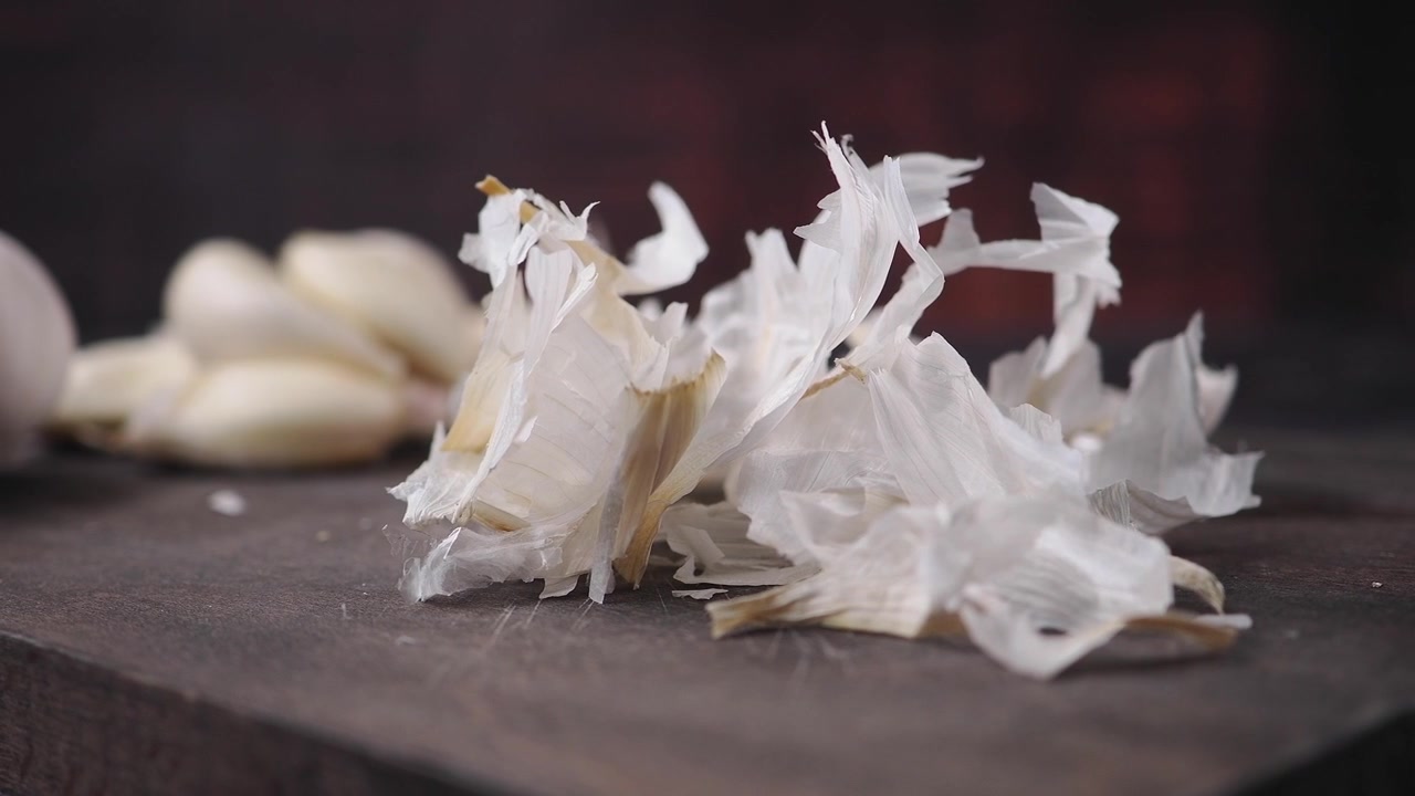 Bucce e spicchi d'aglio su un tagliere di legno