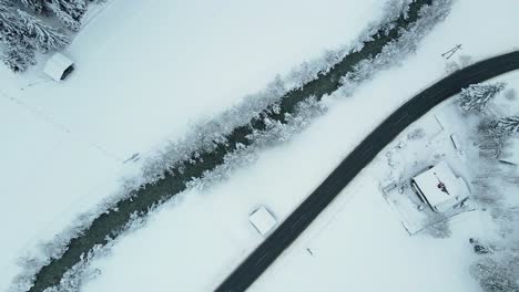 aerial shot of a snow covered mountain town, winding road through the valley