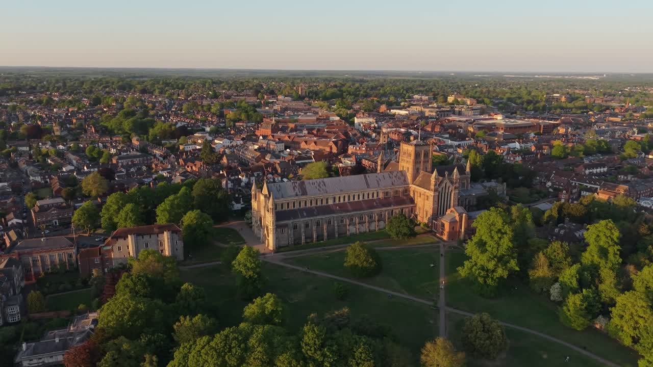 Cinematic aerial footage orbits over St Albans, a picturesque city in a London suburb, capturing its historic architecture, charming streets, and scenic urban landscape