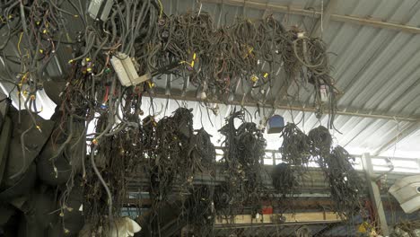 different car parts and accesories hanging from the ceiling of a machine shop in bangkok, thailand