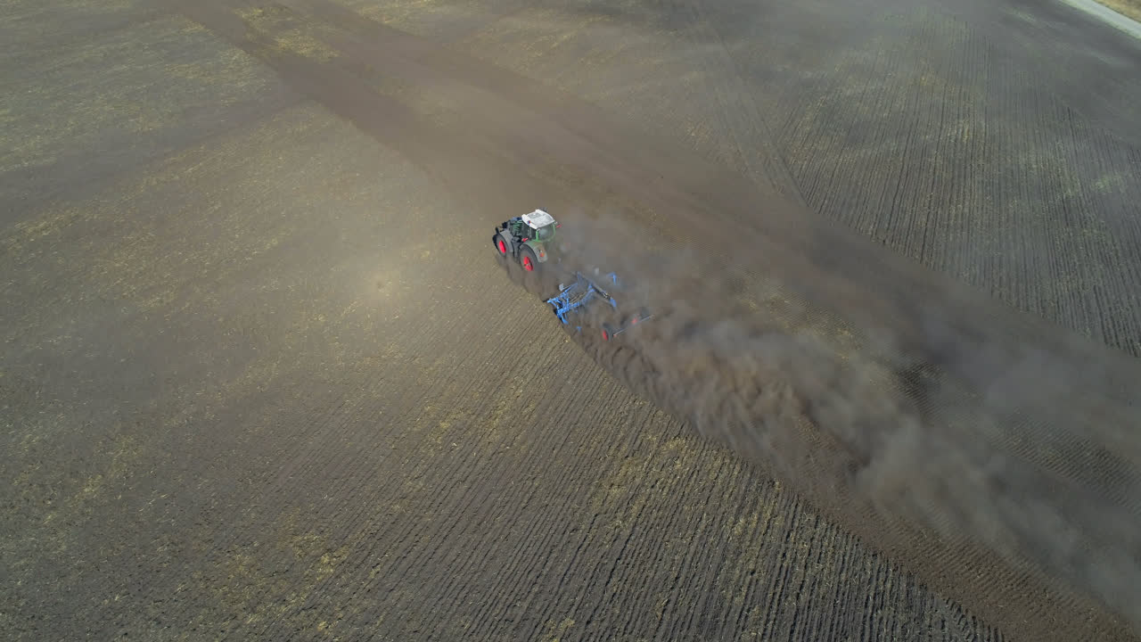 Vista aérea de trator se movendo em campo colhido 4k