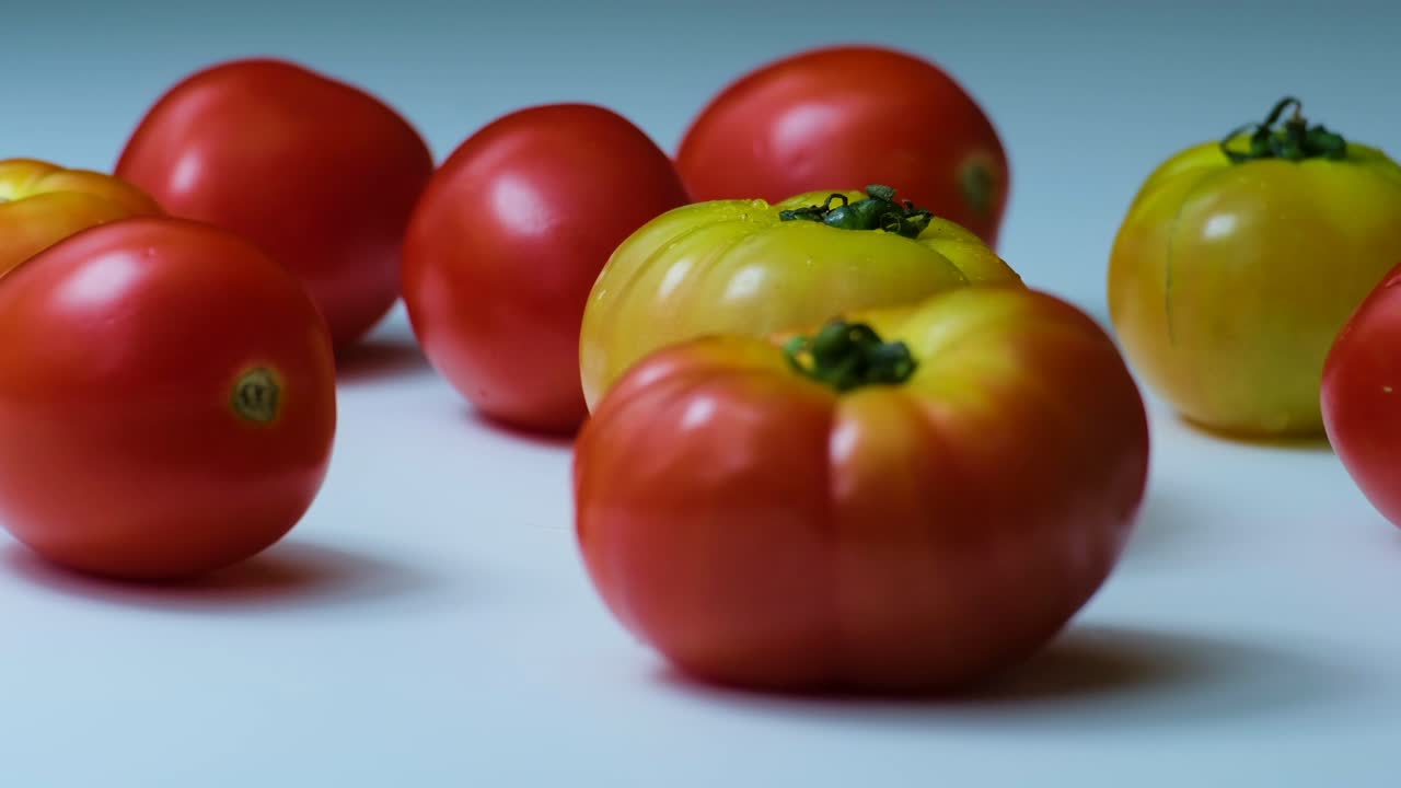 circulando una colección de tomates de reliquia en una mesa blanca