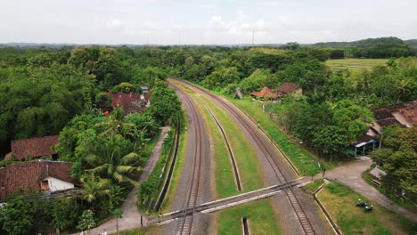 Aerial-view-of-train-rail-dividing-the-countryside-in-Magelang,-Indonesia