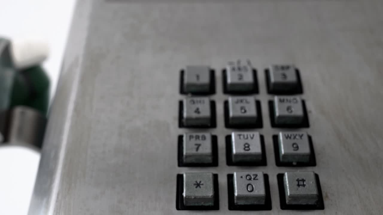 primer plano de los botones de los teléfonos públicos. mira hacia arriba. toca de derecha a izquierda.