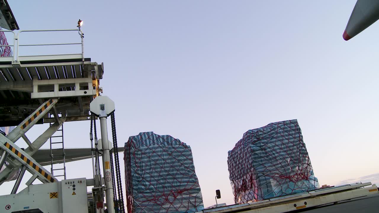 Twilight airport scene with cargo loading onto an airplane