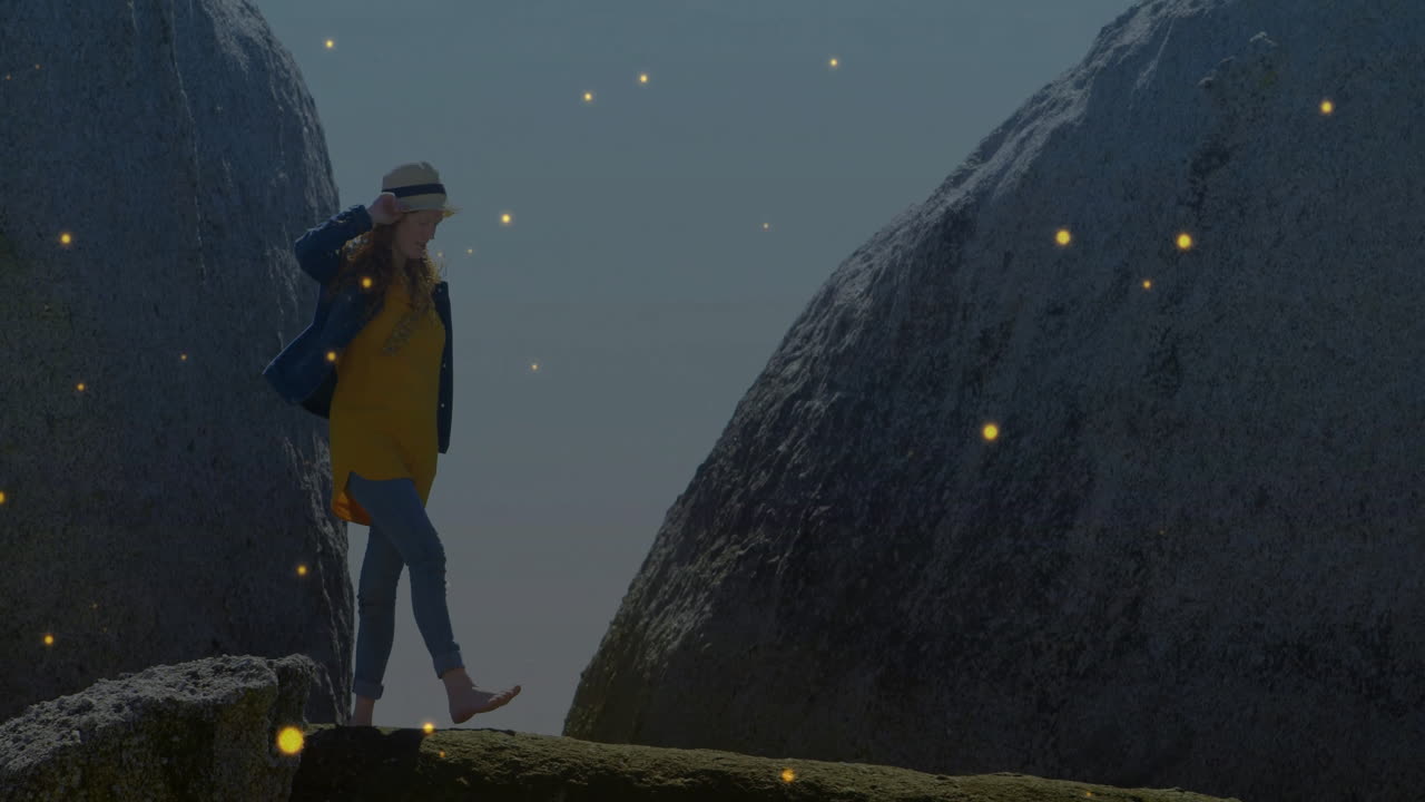 Walking on rocky path, woman in hat surrounded by glowing animation particles