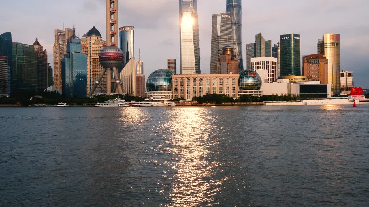 shanghai skyline viewed from bund, skyscrapers and landmarks with sunset light reflections on the ripples of Huangpu river, loop able 4k b roll footage.