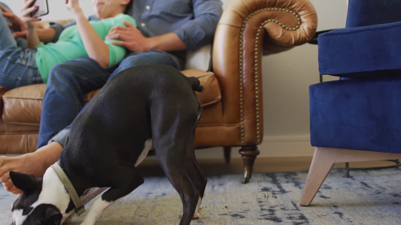 사랑에 빠진 젊은 행복한 백인 커플이 집에서 태블릿을 사용하고 이야기하고 있습니다.