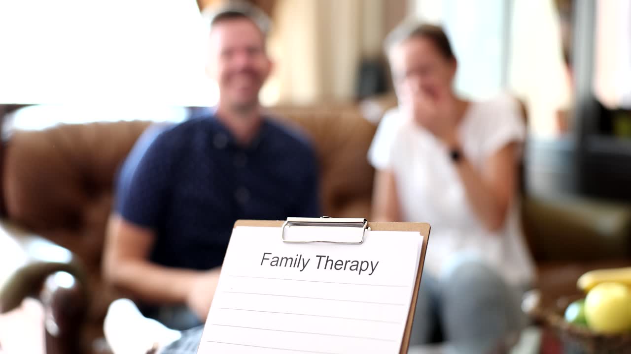 Familieterapisession med par i baggrunden