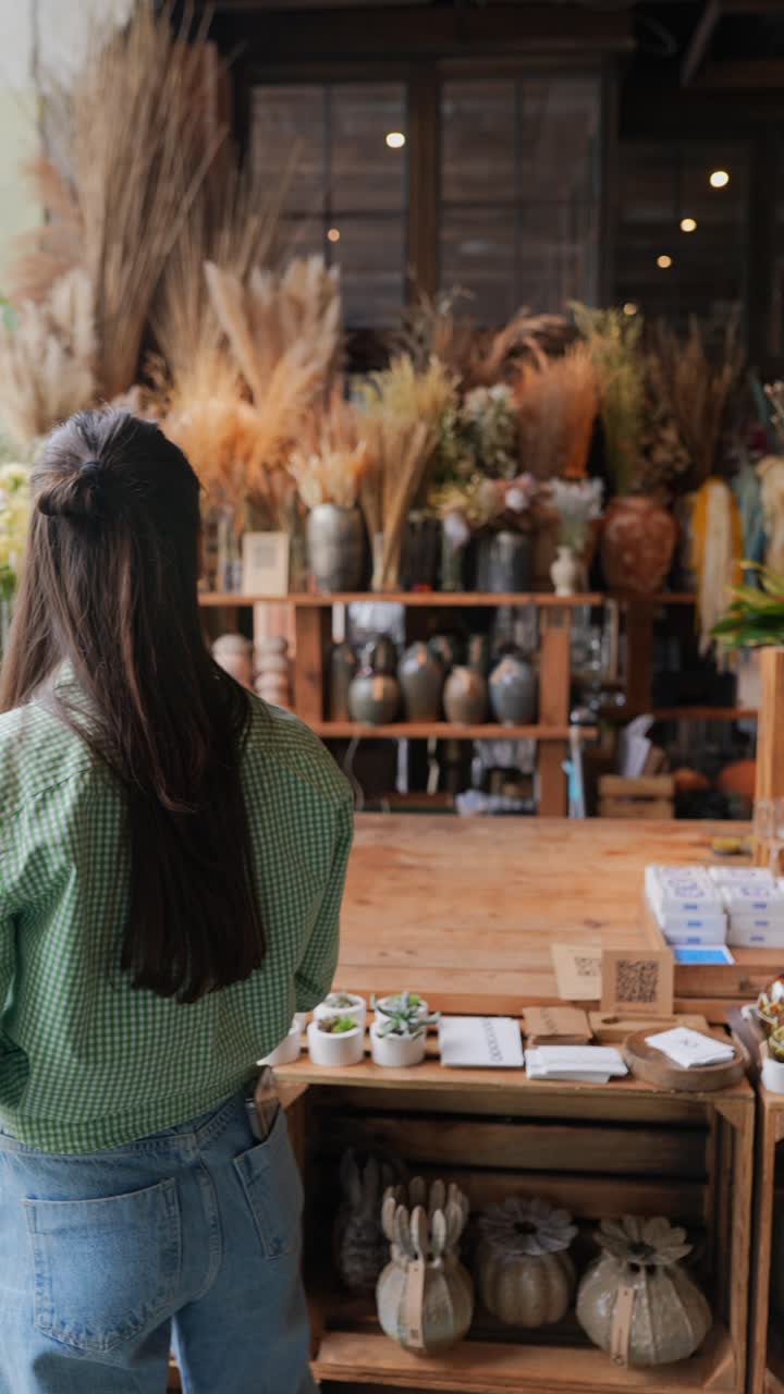 una mujer mirando una tienda de flores.