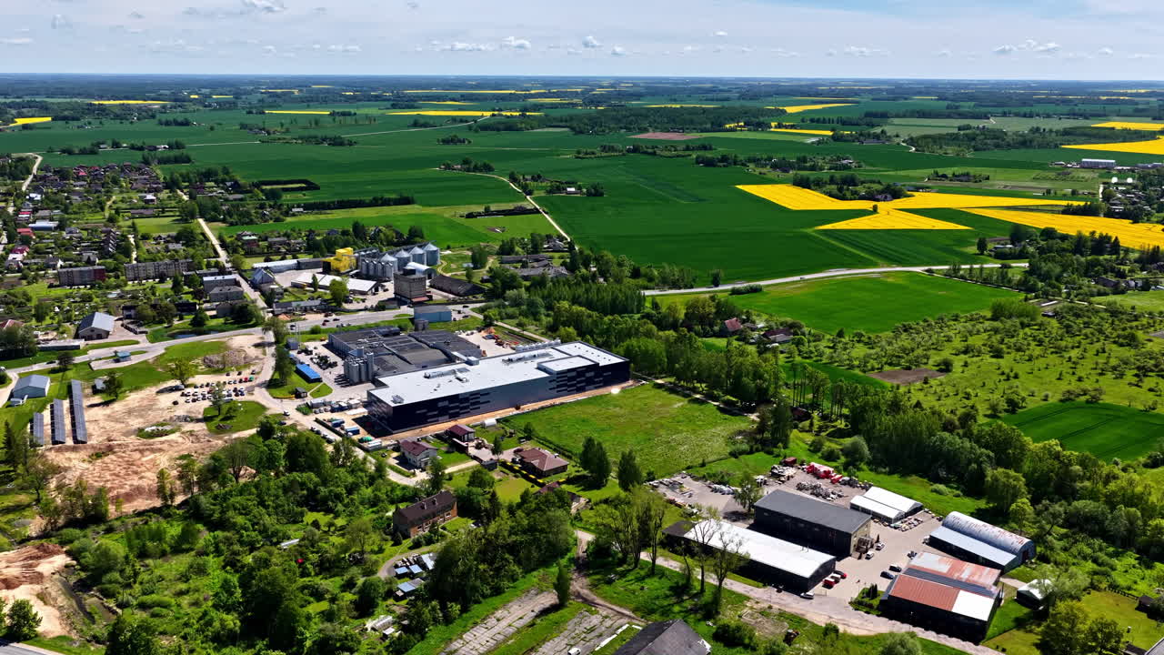 Industrial sorting facility surrounded by farmland, wide panoramic aerial with roads