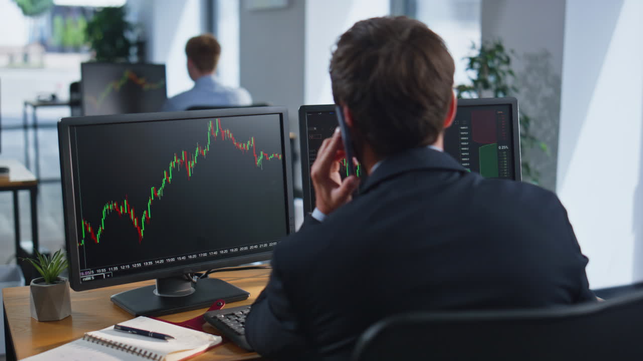 Financial trader talking smartphone sitting workplace with monitors closeup